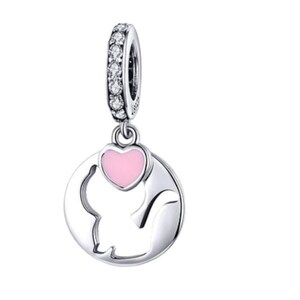May include: A silver charm with a cat silhouette and a pink heart. The charm has a ring adorned with clear stones. The cat is inside a circular frame. A cute and charming piece of jewelry.