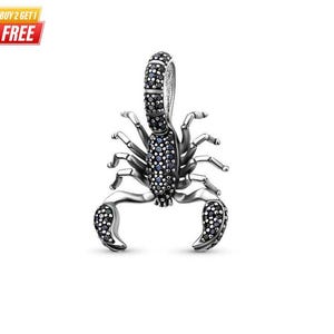 May include: A scorpion-shaped pendant crafted from dark oxidised silver, featuring a curved tail and two large pincers. The body, tail, and pincers are encrusted with numerous small, dark black stones that provide a textured, shimmering appearance.