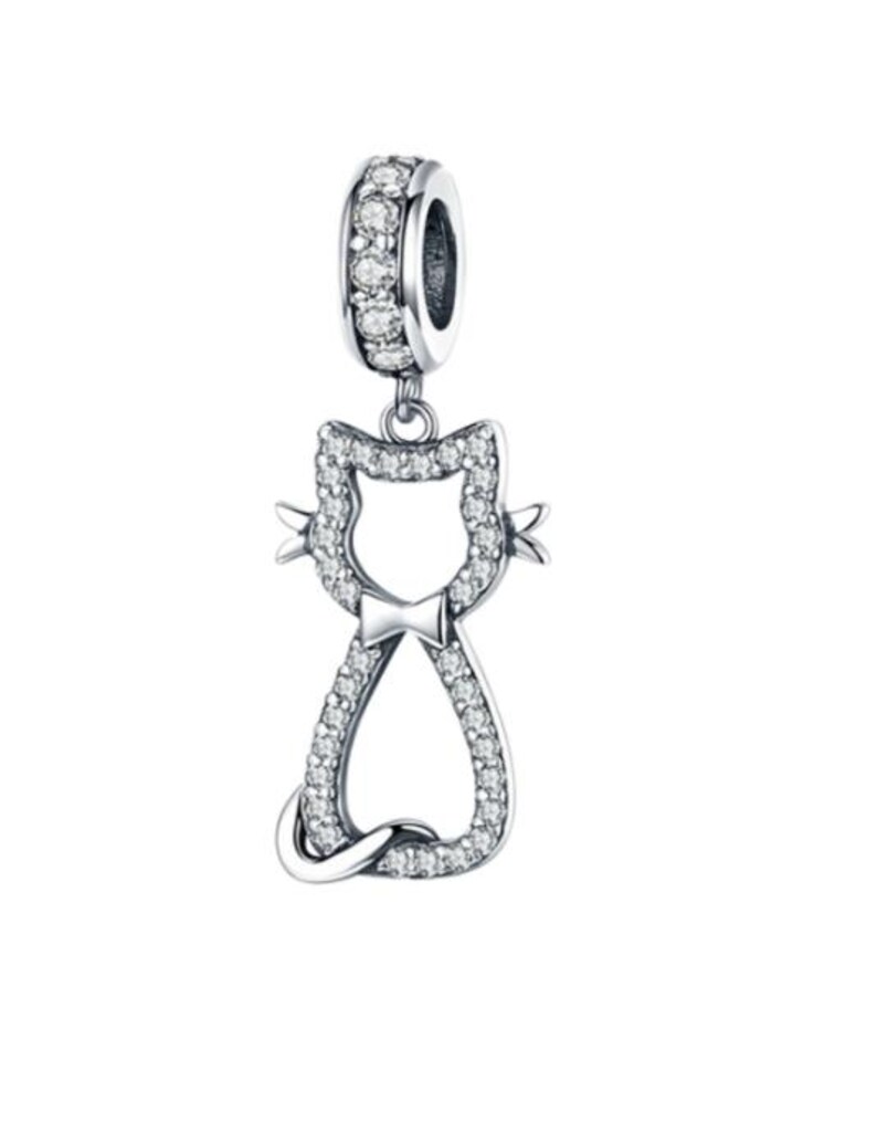 May include: A silver-colored cat charm with a bow tie, encrusted with clear crystals. The charm has a loop at the top, also adorned with crystals, for attaching to a bracelet or necklace. The cat's silhouette is detailed with sparkling stones.