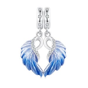May include: A pair of silver charm pendants with blue enamel angel wings. Each wing has feather detailing and clear crystal accents. The pendants hang from a silver hoop with three small crystals.