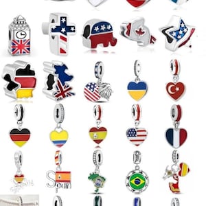 Könnte beinhalten: Eine Sammlung von Silberanhängern mit verschiedenen Landesflaggen und Symbolen. Die Anhänger umfassen herzförmige Designs, Anhänger in Flaggenform und ikonische Wahrzeichen. Die Anhänger sind in verschiedenen Farben erhältlich, darunter Rot, Weiß, Blau, Gelb und Grün.