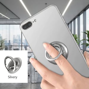 May include: Silver phone ring holder attached to a silver smartphone. The ring is being held by a finger. The phone has a dual-lens camera. The word "Silvery" is printed on a white background.