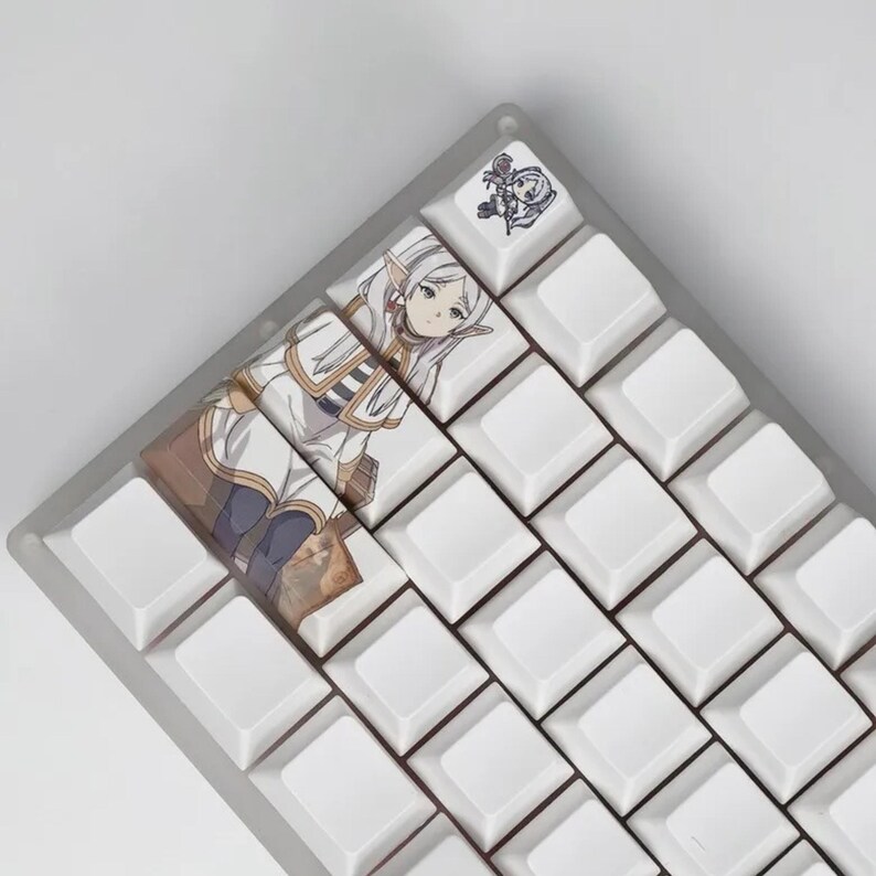 May include: A custom keyboard with white keycaps and a clear frame. Some keycaps feature anime-style artwork of a female character in a white and brown outfit. The top right keycap has a small illustration.