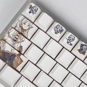 May include: White mechanical keyboard keycaps with anime-style character art. The keycaps feature illustrations of a female elf character and other small character designs. The keyboard keys are arranged in a grid pattern.