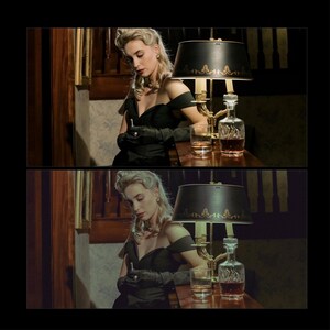 May include: A woman in a black off-the-shoulder dress and black gloves sits at a bar, looking down at a small object in her hand. A lamp with a black shade and a decanter of liquor are on the bar in front of her.