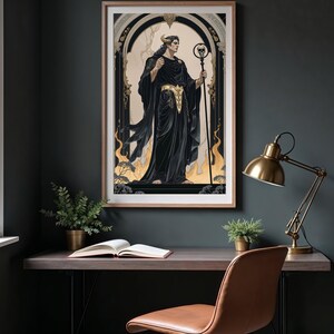 May include: Framed art print featuring a figure in black robes with gold accents, holding a staff topped with a skull. The artwork has a gothic theme, set against a beige background with gold flames and a dark frame. The print is displayed on a dark wall.