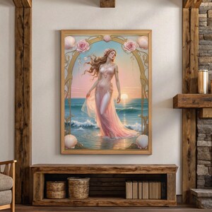 Op de afbeelding: Een ingelijste kunstdruk toont een vrouw in een vloeiende roze jurk in de oceaan bij zonsondergang. Het kunstwerk heeft een gouden lijst met schelp- en bloemdetails en een serene oceaanachtergrond.