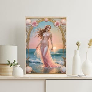 Op de afbeelding: Een ingelijste kunstdruk toont een vrouw in een roze jurk in de oceaan bij zonsondergang. Het kunstwerk is omlijst met gouden accenten, schelpen en roze rozen. De oceaan en de lucht zijn in tinten blauw en roze.