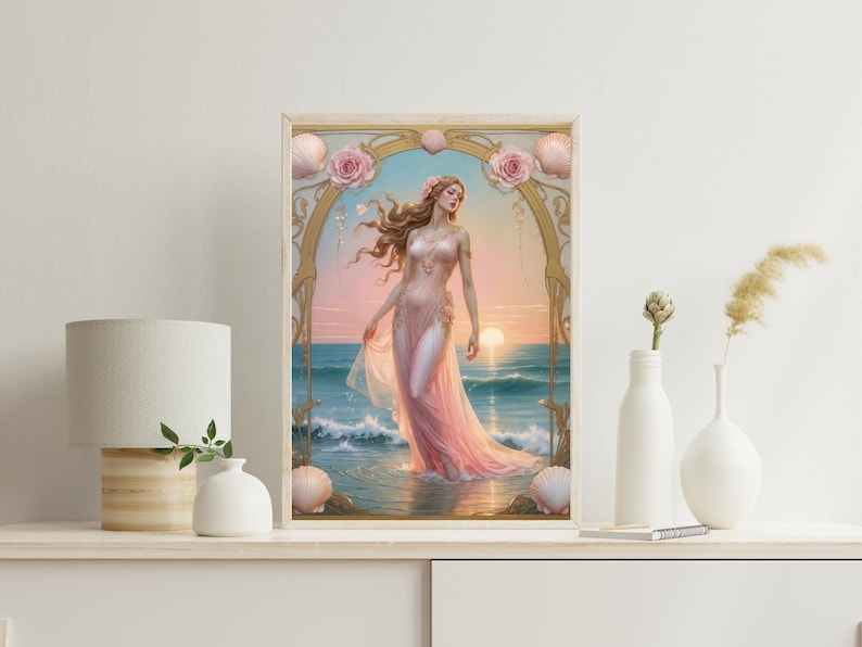 Op de afbeelding: Een ingelijste kunstdruk toont een vrouw in een roze jurk in de oceaan bij zonsondergang. Het kunstwerk is omlijst met gouden accenten, schelpen en roze rozen. De oceaan en de lucht zijn in tinten blauw en roze.