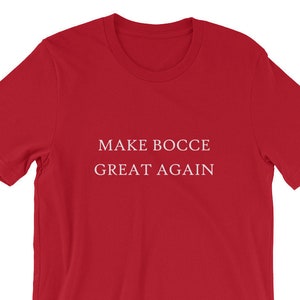 以下が含まれることがあります： 白文字で「MAKE BOCCE GREAT AGAIN」と書かれた赤い半袖Tシャツ。