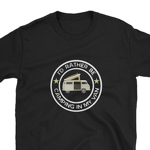 Könnte beinhalten: Schwarzes T-Shirt mit einem weißen Kreis-Motiv, auf dem "Ich würde lieber im Van campen" steht. Das Motiv enthält auch einen gelben Stern auf jeder Seite und ein Cartoon-Bild eines weißen Vans mit einem aufklappbaren Dach.