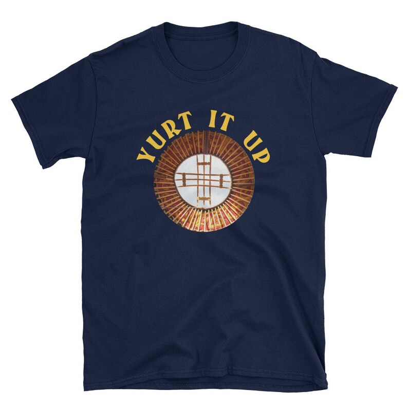 May include: A navy blue t-shirt with the text "Yurt It Up" in yellow letters and a circular graphic of a yurt roof with a white cross in the center.