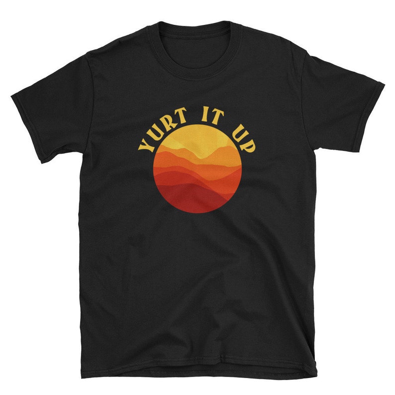K&ouml;nnte beinhalten: Schwarzes T-Shirt mit einem Grafikdruck eines Sonnenuntergangs &uuml;ber Bergen in einem Kreis mit dem Text "Yurt It Up" in einer Retro-Schrift.