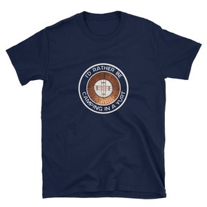 Peut inclure: Un t-shirt bleu marine avec un graphique circulaire blanc qui dit "J'aimerais mieux camper dans une yourte". Le graphique repr&eacute;sente une yourte stylis&eacute;e avec une croix &agrave; l'int&eacute;rieur.