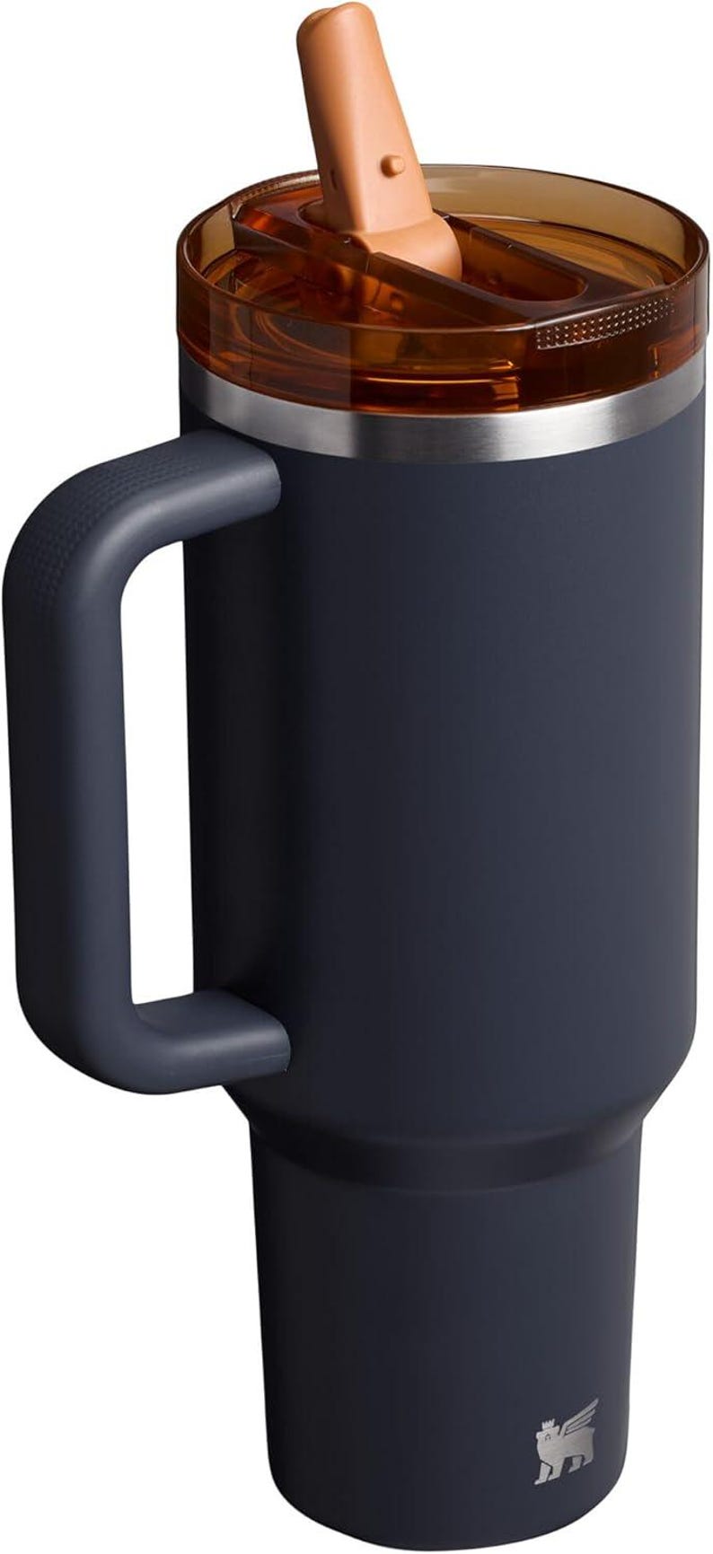 Puede incluir: Un vaso t&eacute;rmico azul marino con asa y tapa transparente. La tapa tiene un cierre abatible marr&oacute;n. El vaso tiene un borde plateado y un logotipo en la parte inferior. Este termo de viaje est&aacute; dise&ntilde;ado para mantener las bebidas calientes o fr&iacute;as.