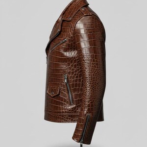 Puede incluir: Chaqueta de cuero marr&oacute;n con efecto piel de cocodrilo. La chaqueta tiene una cremallera asim&eacute;trica, un peque&ntilde;o bolsillo y cremalleras en las mangas. La chaqueta es de color marr&oacute;n medio.