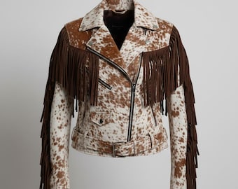May include: A brown and white cowhide leather jacket with fringe detailing on the sleeves and shoulders. The jacket features a zip-up front, a belt at the waist, and a classic biker jacket design.