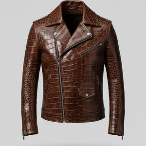 Puede incluir: Chaqueta de cuero marr&oacute;n con textura de piel de cocodrilo. La chaqueta, de estilo motero, tiene cuello con solapas, cremallera asim&eacute;trica y varios bolsillos. Las mangas tienen cremalleras en los pu&ntilde;os.
