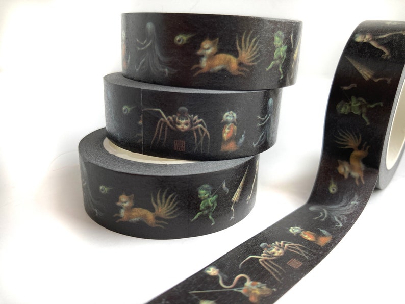 May include: Three rolls of black washi tape with a dark fantasy design. The tape features illustrations of a spider, a fox, and other creatures.