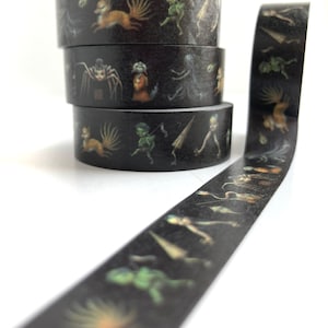 May include: A roll of black washi tape with a repeating pattern of whimsical creatures in shades of green, brown, and white. The tape features a fox, a spider, a goblin, and other fantastical beings.