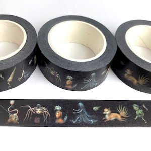 May include: Three rolls of black washi tape featuring a repeating pattern of colourful creatures and figures. The tape is decorated with a variety of mythical creatures, including a spider, a fox, a ghost, and a goblin.