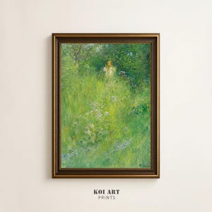 May include: A framed art print depicting a figure in a white dress amidst tall green grass and foliage. The artwork is enclosed in a dark brown wooden frame. The print includes the text "KOI ART PRINTS" at the bottom, suggesting a gallery or print shop.