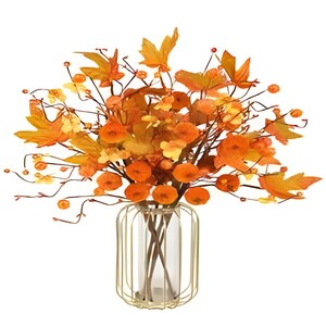 May include: A fall-themed floral arrangement in a clear glass vase with a gold metal cage. The arrangement features orange and yellow leaves, berries, and small orange flowers. The leaves are shaped like maple leaves.