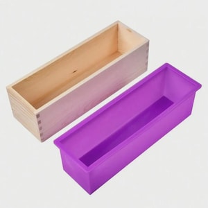 Puede incluir: Una caja rectangular de madera y un molde rectangular morado. La caja de madera es de madera clara. El molde morado es de material flexible. El texto en la parte superior de la imagen dice "Wooden box + Purple mold".