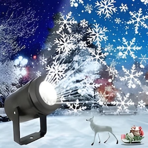 Könnte beinhalten: Ein schwarzer Projektor wirft weiße Schneeflockenmuster auf eine Winterszene. Ein weißes Reh und ein Schlitten mit Geschenken befinden sich im Vordergrund. Der Hintergrund zeigt einen verschneiten Wald und einen blauen Himmel.