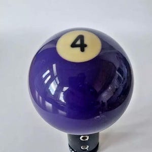 May include: Purple billiard ball gear shift knob with a white number 4 on it.