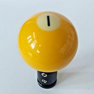 May include: Yellow billiard ball gear shift knob with a black base and the number "1" on it.