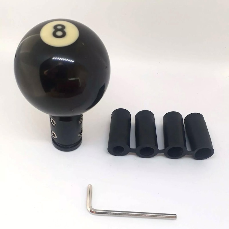 May include: Black 8-ball gear shift knob with a silver metal base and four black rubber shift boot adapters. A silver metal allen wrench is also included.