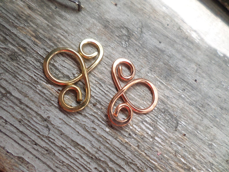 May include: Two wire loops, one gold and one copper, in the shape of a figure eight.