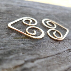 May include: Gold wire earrings with a geometric design featuring three interlocking circles.