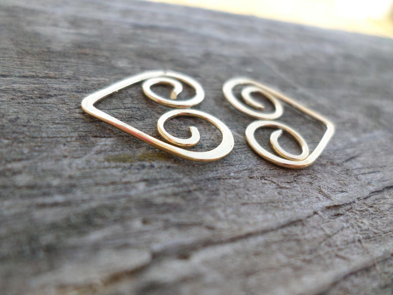 May include: Gold wire earrings with a geometric design featuring three interlocking circles.