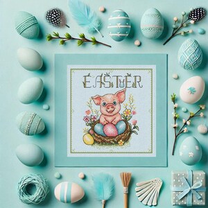 Puede incluir: Una tarjeta azul claro con la palabra "Easter" en una pancarta verde y un cerdito rosa sentado en un nido de huevos coloridos. El cerdito est&aacute; rodeado de flores y hojas verdes. La tarjeta est&aacute; rodeada de huevos azul pastel y otras decoraciones de Pascua.
