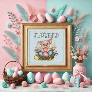 Puede incluir: Un patr&oacute;n de punto de cruz con un cerdito rosa sentado en un nido de huevos de Pascua. El patr&oacute;n est&aacute; enmarcado en un marco de madera claro y el texto "Easter" est&aacute; sobre el cerdito. La imagen est&aacute; rodeada de fondos rosa pastel y azul con huevos de Pascua decorativos y flores.