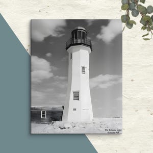 May include: A black and white photograph of a lighthouse with a white exterior and black trim. The lighthouse is tall and slender, with a conical roof and a small window at the top. The lighthouse is set against a cloudy sky.