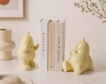 Handgemaakte keramische boekensteun met een schattig geel dierenmotief; een minimalistisch, modern bureauaccessoire.