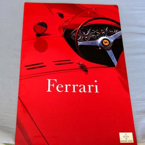 May include: A red Ferrari sports car with a black steering wheel and a yellow prancing horse logo. The car is on a red background with the word "Ferrari" in white text.