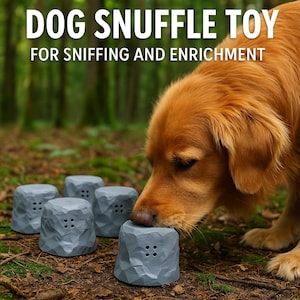 May include: A golden retriever sniffs a gray dog snuffle toy shaped like a rock. The toy has multiple holes for hiding treats. The text "DOG SNUFFLE TOY FOR SNIFFING AND ENRICHMENT" is at the top of the image.