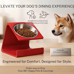 May include: A red angled pet bowl stand with a stainless steel bowl filled with brown kibble. The stand features the embossed text WITTY. A small rectangular plaque reads PENN3D: Precision-Crafted. Text includes ELEVATE YOUR DOG'S DINING EXPERIENCE.