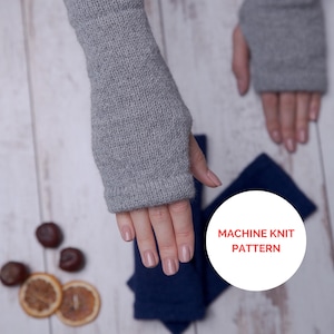 Könnte beinhalten: Graue Fingerlose Handschuhe aus maschineller Strickware. Die Handschuhe sind auf einer Holzoberfläche mit getrockneten Orangenscheiben und Kastanien abgebildet.