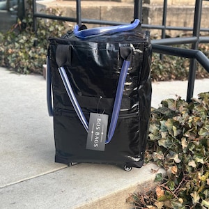 May include: Black rolling tote bag with blue handles and a white tag that says "Boss Bags".