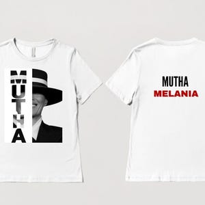 May include: White t-shirt with a black and white image of a woman wearing a hat and the text "MUTHA" on the front. The back of the shirt has the text "MUTHA MELANIA" in black and red.
