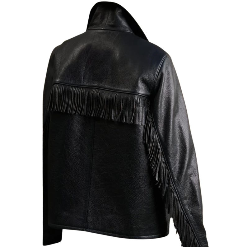 May include: Black leather jacket with fringe detailing across the back and down the sleeves. The jacket has a classic collar and a textured appearance, offering a stylish, edgy look. A fashionable outerwear piece.