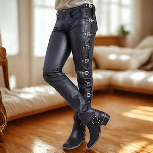 May include: Black leather pants with multiple silver buckles running down the side of each leg. The pants are paired with black leather boots with silver hardware. The pants appear to be made of a shiny, smooth leather material.
