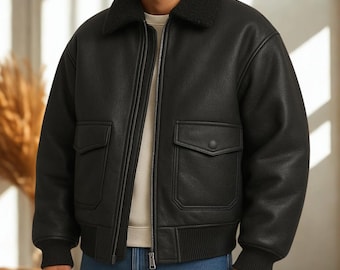 May include: Black bomber jacket with a faux shearling collar, two front pockets with button closures, and a ribbed hem and cuffs. The jacket has a zip-up front and a classic, timeless design.