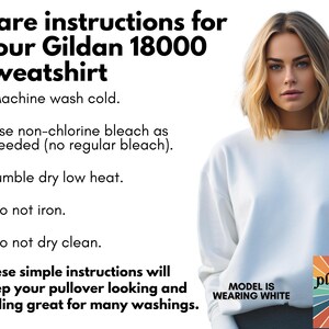 May include: White Gildan 18000 sweatshirt with care instructions. The text includes washing instructions: machine wash cold, use non-chlorine bleach, tumble dry low heat, do not iron, and do not dry clean. The model is wearing white.