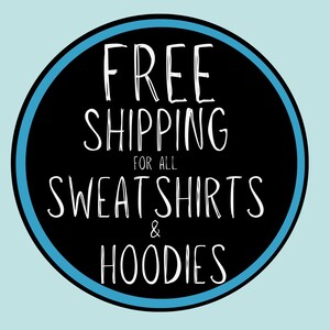 May include: A circular graphic with a black center and a bright blue border. The text in white, handwritten-style font reads: FREE SHIPPING FOR ALL SWEATSHIRTS & HOODIES. The design is set against a solid, light blue background.